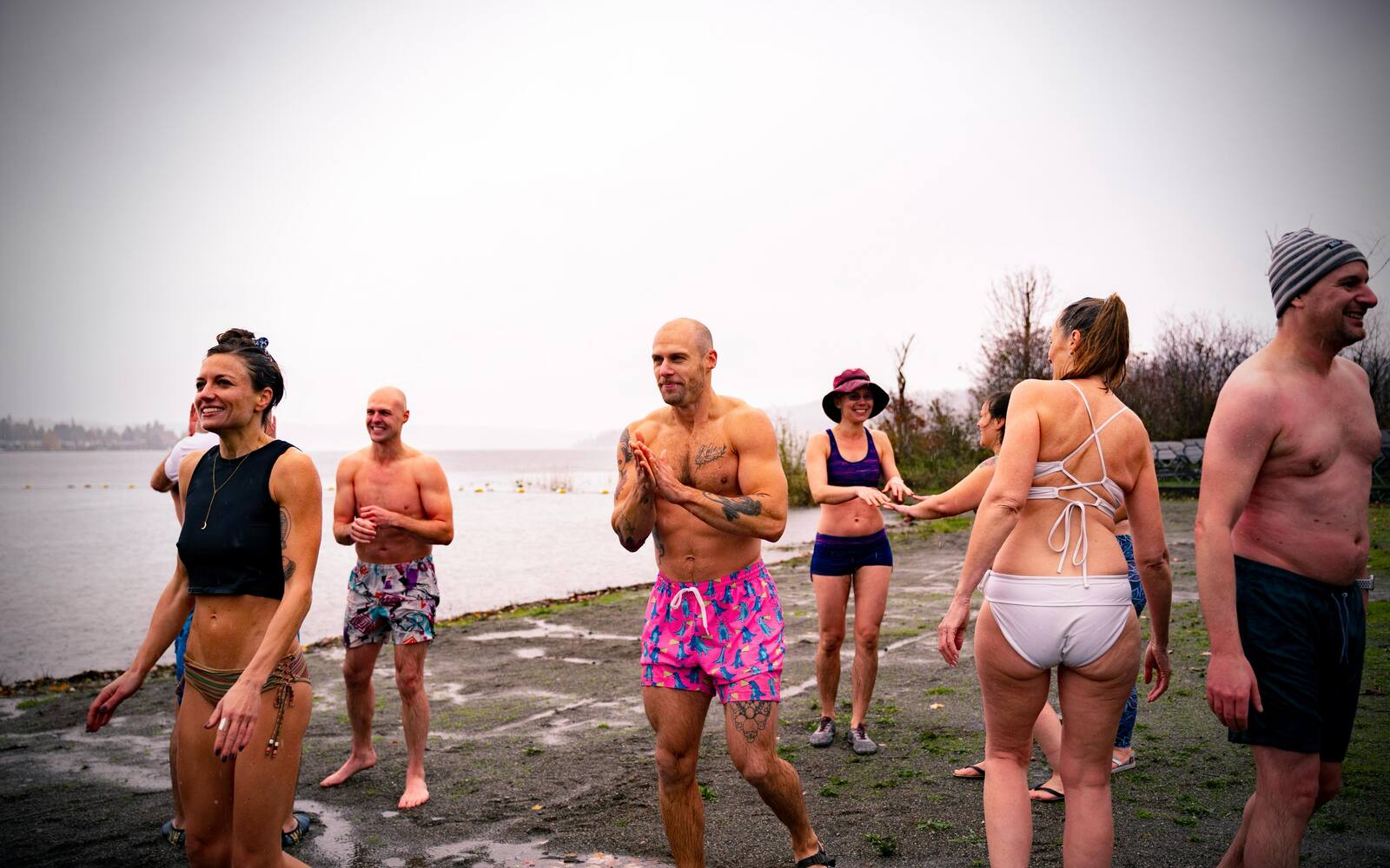 A group on the lake shore on a grey morning, warming up after the water